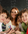 Eine Lehrerin mit mehreren fröhlichen Schüler/innen