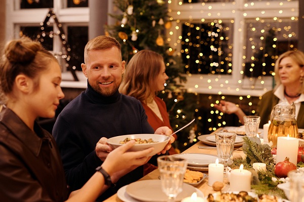 Mann gibt Kind Salatschüssel beim Weihnachtsessen - Bild: pexels.com